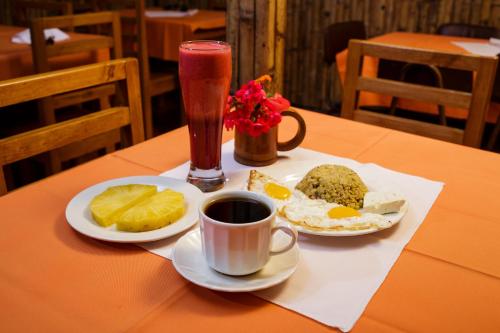 una mesa con dos platos de comida y una bebida en Estancia, CABAÑAS INTAG, en Vacas Galindo