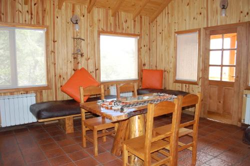sala de estar con mesa de madera y sillas en Parajes del lejano sur cabaña El Cardo in 