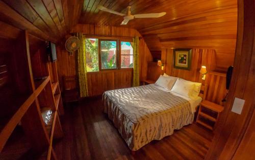 a bedroom with a bed in a wooden cabin at Hotel Rio Grande Lodge in San Ramón