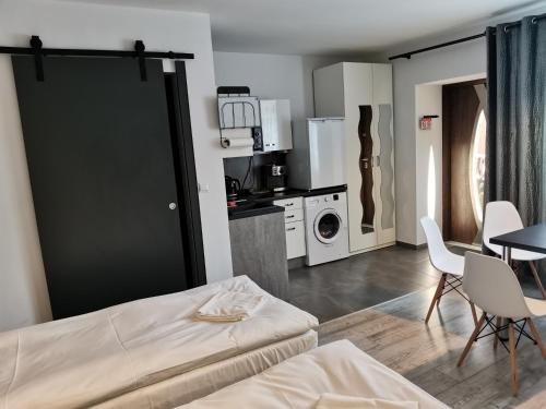 a room with a bed and a table and a kitchen at Apartamenty Jaskinia Solna in Ruda Śląska