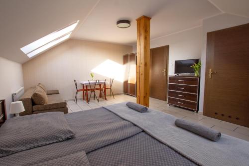1 dormitorio con 1 cama y sala de estar con mesa en Villa Sol, en Grzybowo