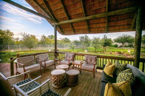 a porch with chairs and a couch on a deck at Shearwater's Explorers Village in Victoria Falls