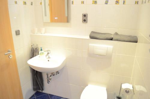 a white bathroom with a sink and a toilet at Wohnung Ahorn in Riedstadt