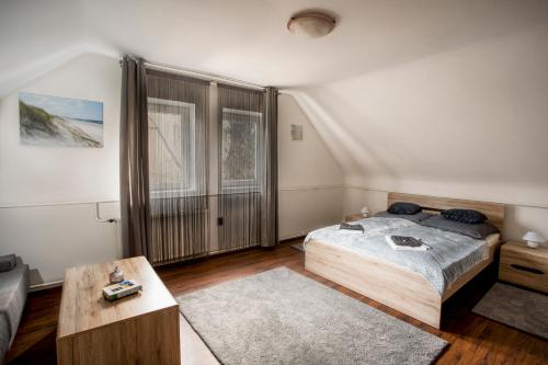 - une chambre avec un lit et une grande fenêtre dans l'établissement Szitakötő Apartman, à Eger