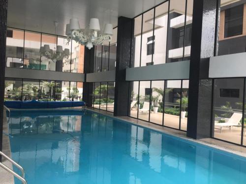 a large swimming pool in a building with windows at 1440 Lujuso Departamento en Quito - La Recoleta in Quito