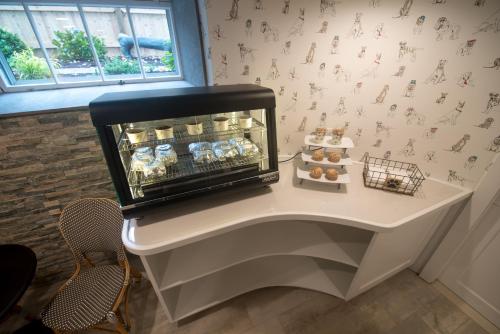 a table in a room with a shelf of pastries at Paws on Pelham in Newport