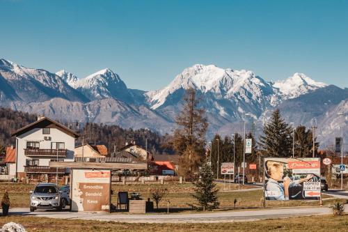 a town with snow capped mountains in the background at Drive Caffe Apartments in Trzin