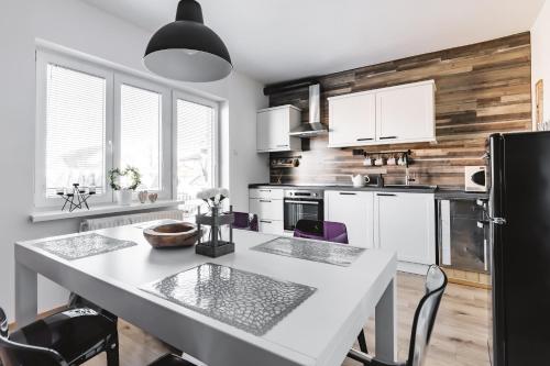 a kitchen with a table and chairs and a refrigerator at Drive Caffe Apartments in Trzin