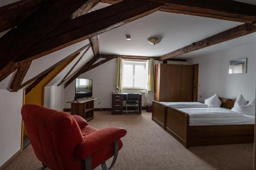 a bedroom with a bed and a desk and a chair at Bistro-Pension Vis-a-Vis in Vohburg an der Donau