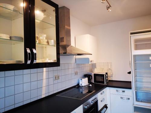 una cocina con encimera negra y electrodomésticos blancos en Homburg Nähe Uniklinik r, en Altstadt