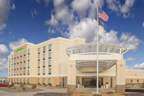 a building with an american flag in front of it at Holiday Inn - Terre Haute by IHG in Terre Haute