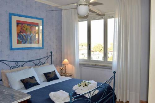 ein Schlafzimmer mit einem Bett und einem Fenster mit Blumen darauf in der Unterkunft Appartamento Deluxe Frontemare in Camaiore