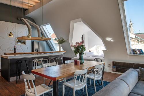 a kitchen and living room with a wooden table and chairs at Central loft Ljubljana in Ljubljana