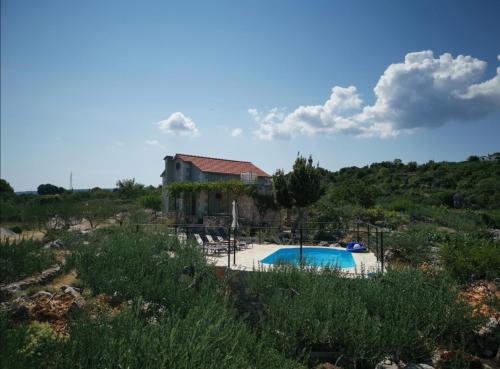 uma villa com uma piscina e uma casa em Robinson crusoe style house "MASLINA'' em Škrip