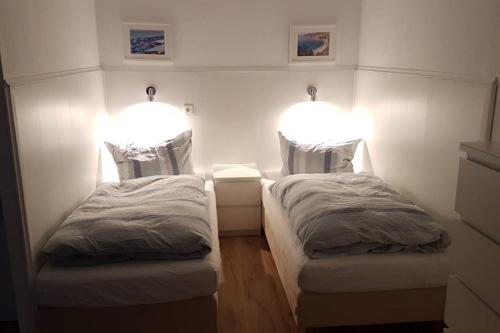 - 2 lits dans une chambre avec des lumières sur le mur dans l'établissement Appartement Vanille, Ferienwohnung mit eigenem Eingang, wie ein kleines Haus, à Bad Salzuflen