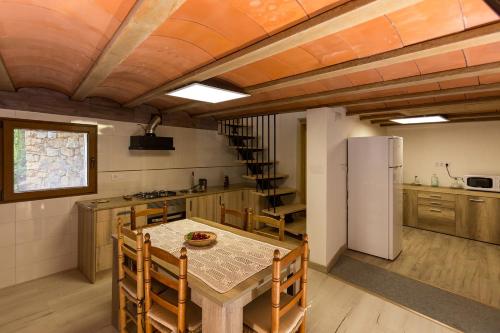 a kitchen with a table and a refrigerator at Casa Rural La Vinyeta in Ballestar