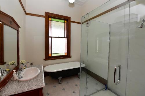 ein Bad mit einer Badewanne, einem Waschbecken und einer Dusche in der Unterkunft Harold House in Reefton