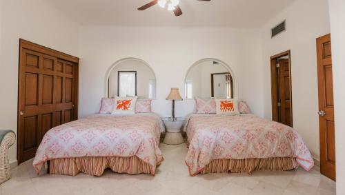 a bedroom with two beds and a mirror at Condominios Ballena in Cabo San Lucas