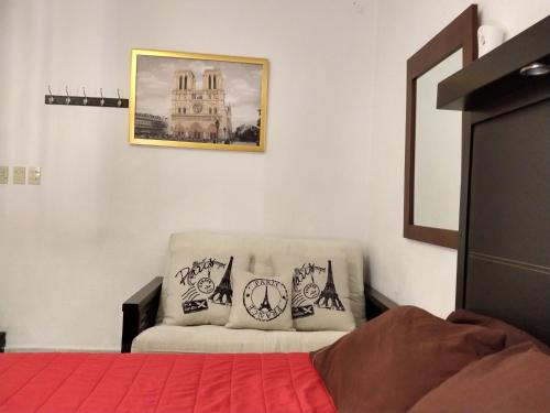 a bedroom with a bed and a chair with pillows at Residence Las Trojes Cdmx in Mexico City