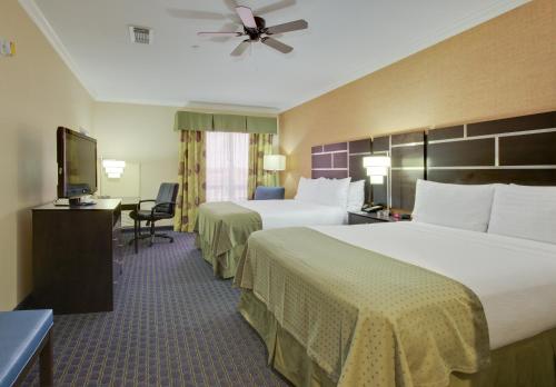a hotel room with two beds and a flat screen tv at Holiday Inn Houston East-Channelview by IHG in Channelview