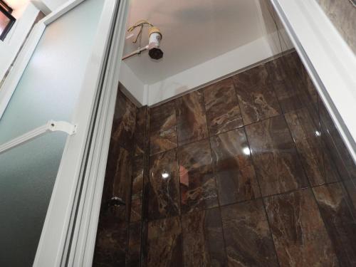 a shower with a glass door in a bathroom at Hotel Adulam in San Pedro La Laguna