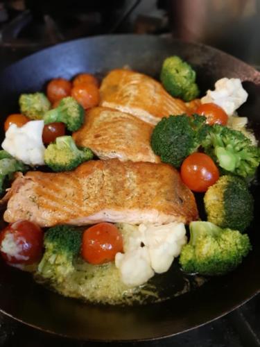 a plate of food with fish broccoli and tomatoes at The Town House Hotel in Naas