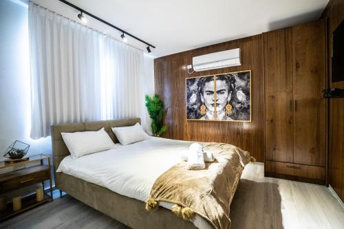 a bedroom with a large bed with a wooden wall at צימר בוטיק אדלה Zimmer boutique adela in Arad