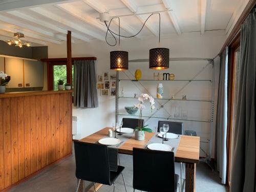 a dining room with a wooden table and chairs at Chalet en pleine nature - le "Clos des Chevreuils" in Barbençon