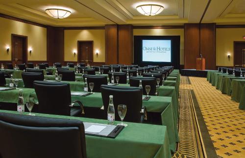 a conference room with green tables and chairs and a screen at Omni Houston Hotel in Houston