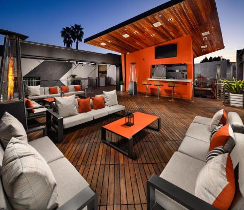 a living room with couches and a kitchen on a deck at The Moment Hotel in Los Angeles