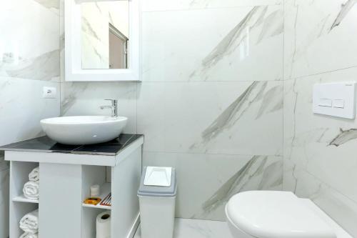 un bagno bianco con lavandino e WC di Villa Doka a Sarandë