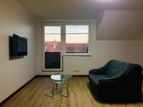 a living room with a couch and a table and a window at Kaunas Castle Apartments - 2 Bedroom Flat in Kaunas