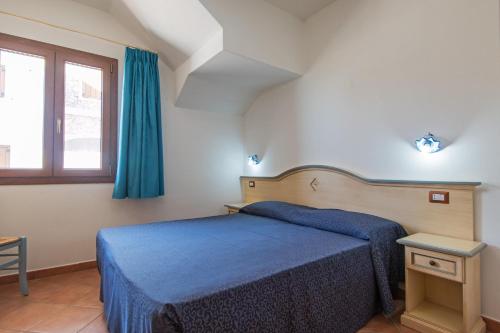 a bedroom with a blue bed and a window at Holiday home in Cala Gonone 34367 in Cala Gonone