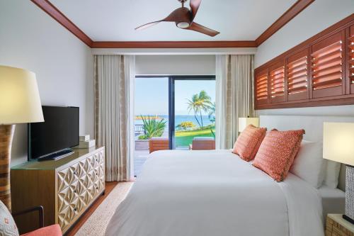 a bedroom with a large bed and a television at Timbers Kauai Ocean Club & Residences in Lihue