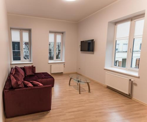 a living room with a couch and a glass table at Kaunas Castle Apartments - One bedroom flat in Kaunas