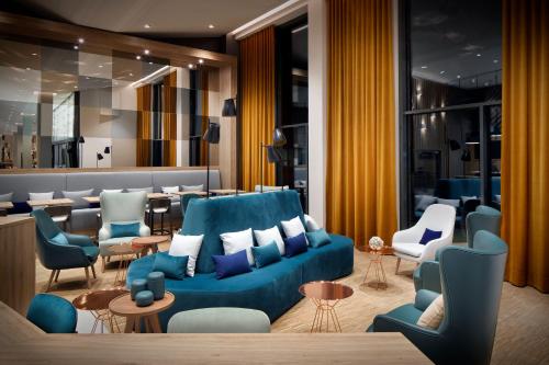 a hotel lobby with a blue couch and chairs at Holiday Inn - Hamburg - HafenCity by IHG in Hamburg