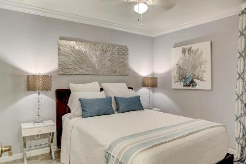 a bedroom with a white bed with blue pillows at La Bella Vita - Luxury Waterfront Condo-Free WIFI-Heated Pool in Tampa