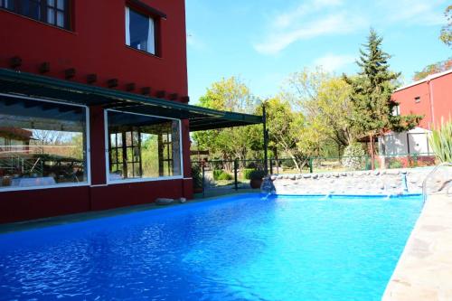 a swimming pool in front of a red building at Nuevas Cabañas Del Sol in San Lorenzo