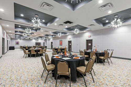 a banquet hall with tables and chairs and chandeliers at Holiday Inn Houston NE-Bush Airport Area by IHG in Humble