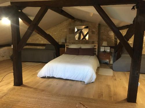 um quarto com uma cama branca num sótão em Au Pied du Chateau em Brantome en Perigord