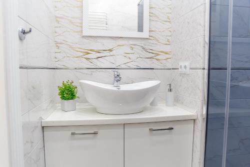 a white bathroom with a sink and a mirror at VIP- Elite Lemberg Apartments in Lviv