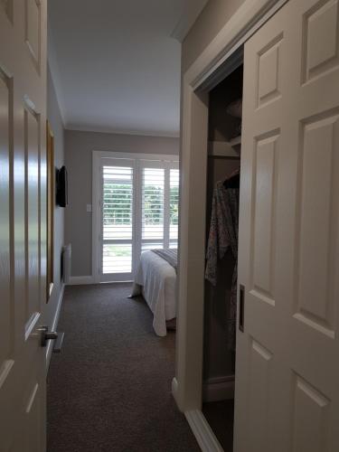 a room with a bed and a door with a window at RIDGETON in Aongatete