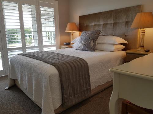 a bedroom with a large bed with two windows at RIDGETON in Aongatete