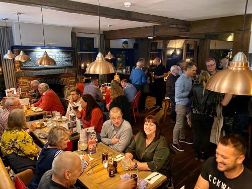 a group of people sitting at tables in a restaurant at The Bull Inn in Mildenhall