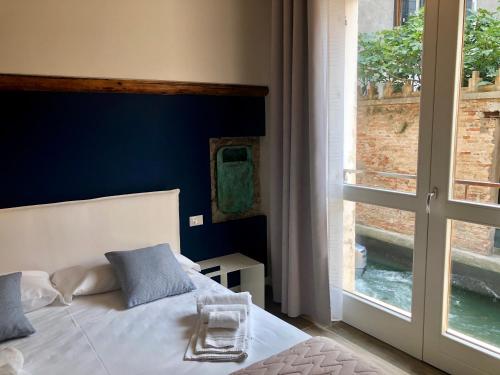 a bedroom with a bed and a large window at Magno Luxury Apt Canal View in Venice
