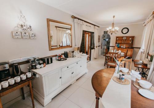 a kitchen with white cabinets and a dining room at Sylvern Bed and Breakfast in Durban