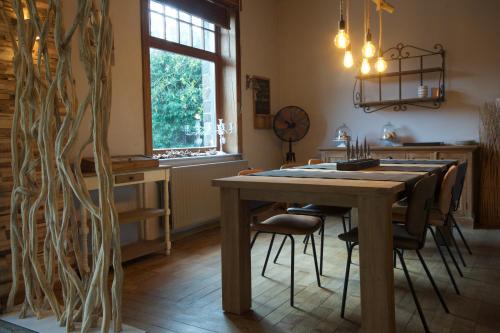 ein Esszimmer mit einem Holztisch und Stühlen in der Unterkunft L'Ancienne Poste - chambres d'hôtes et table de dégustation in Marloie