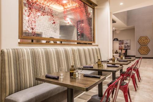 a restaurant with wooden tables and red chairs at Holiday Inn Portland West - Hillsboro by IHG in Hillsboro