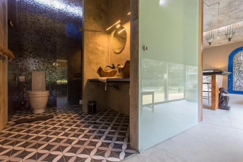 a bathroom with a toilet and a tile floor at Villa Astrolabio Refugio in Boa Vista