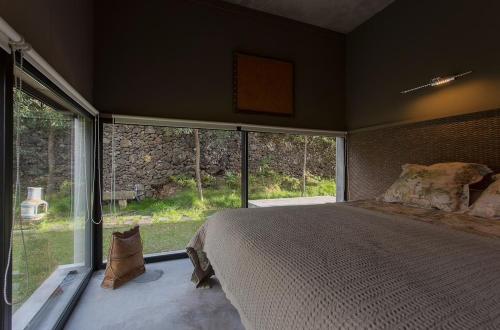 a bedroom with a large bed and a large window at Villa Astrolabio Refugio in Boa Vista